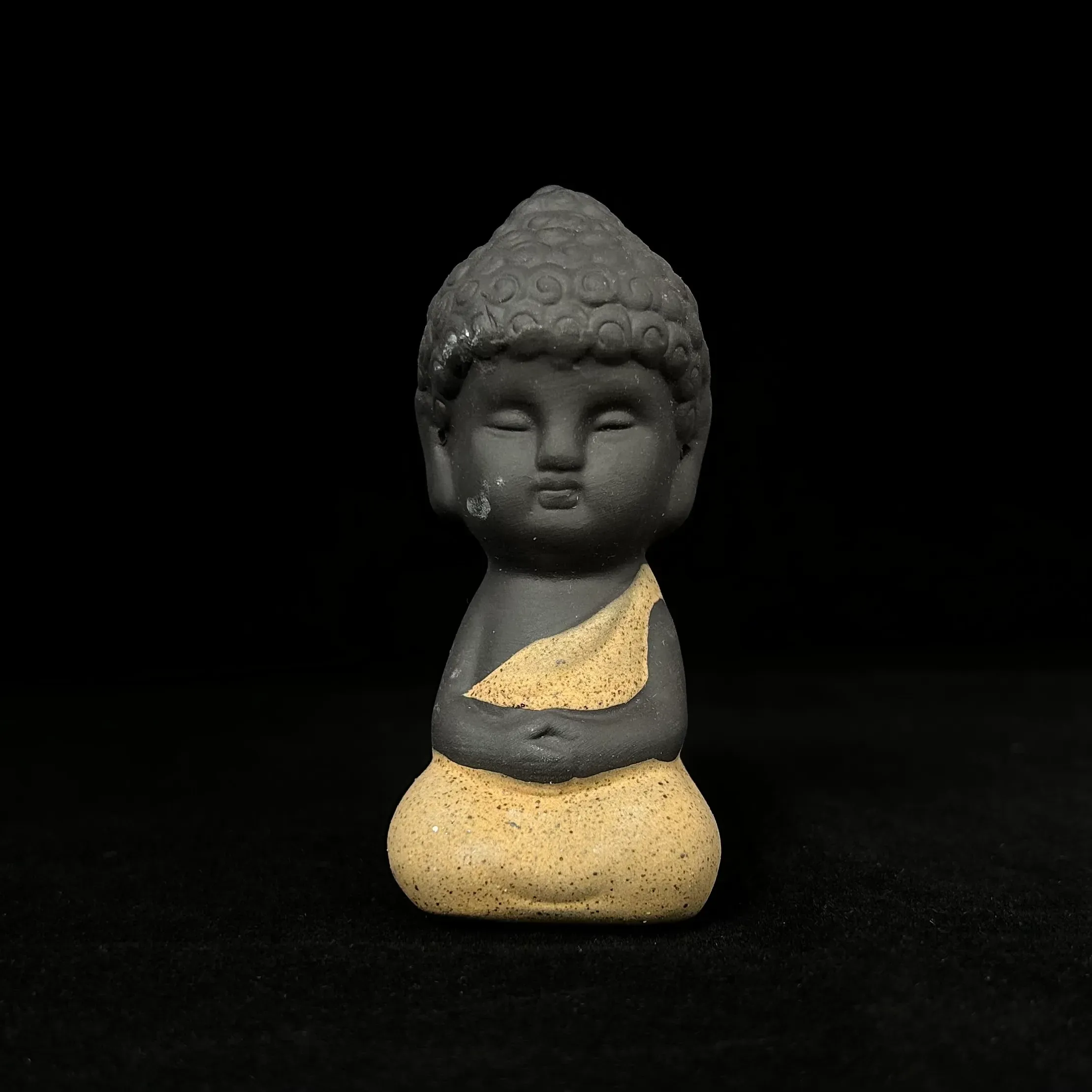 Serenity Buddha figurine against black background.