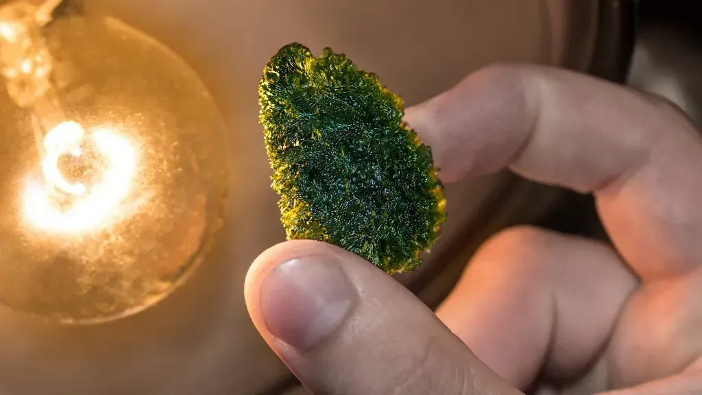 Person examining specimen of Moldavite.