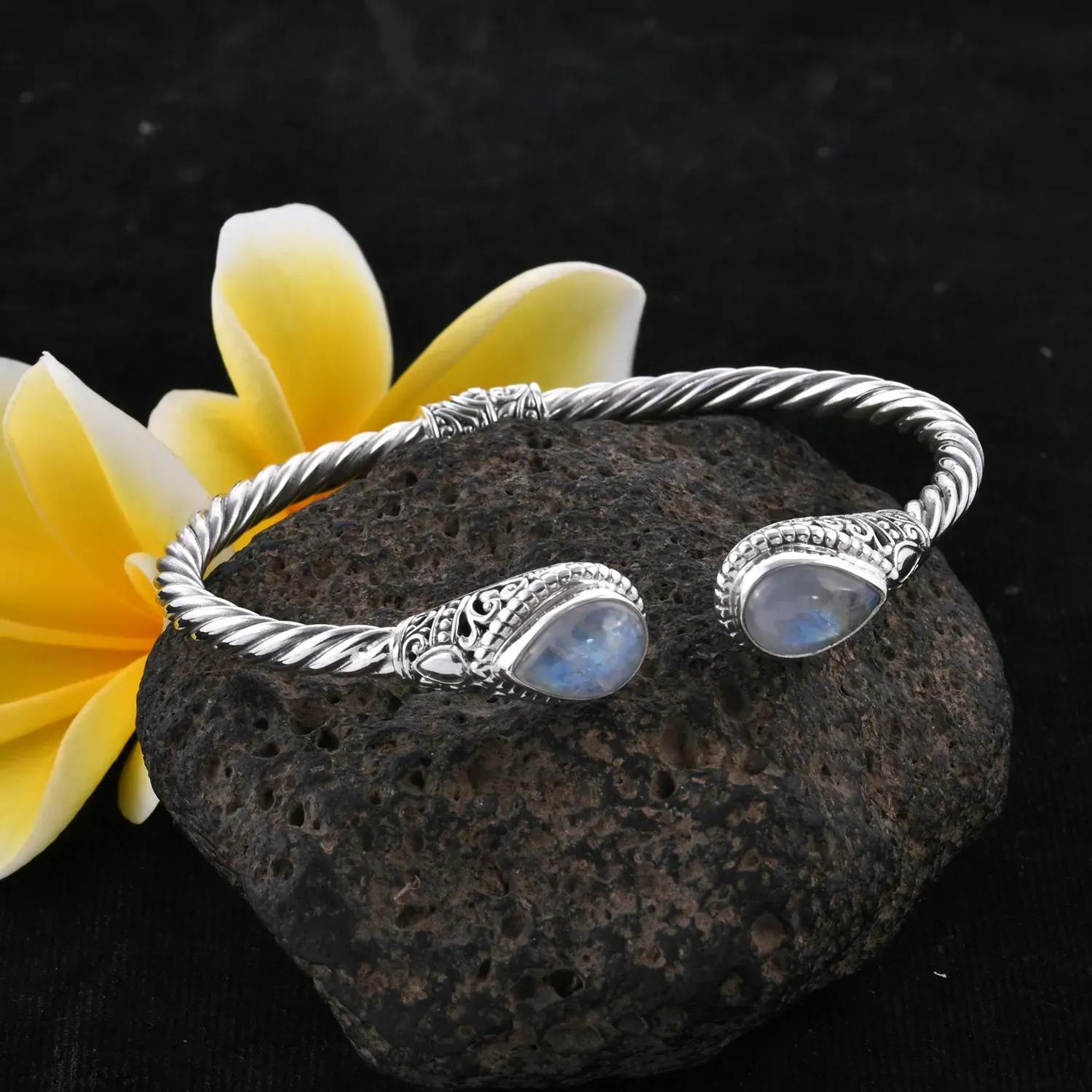 Moonstone bangle perched on lava rock. 