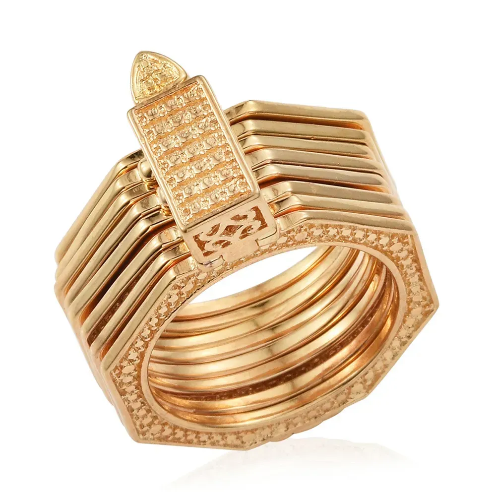 Set of gold bracelets against white background.