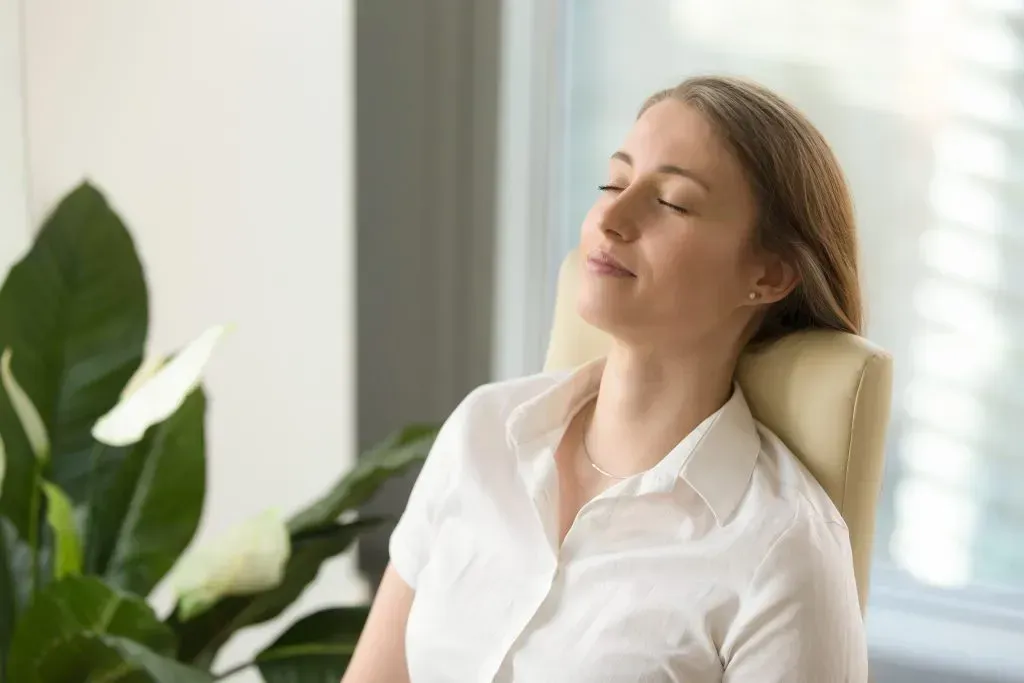 Woman taking a power nap in her office chair.