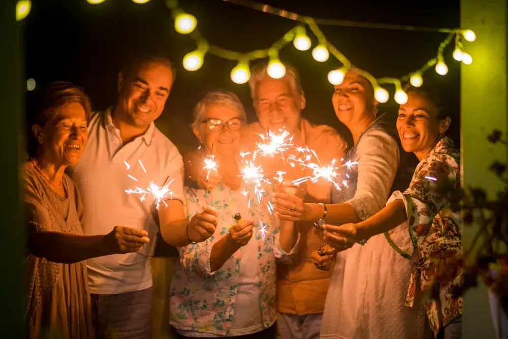 Group of friends celebrate New Year's Eve with sparklers.