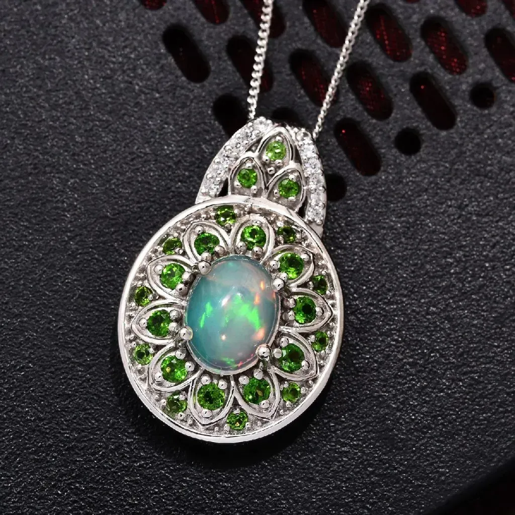 Welo opal pendant in silver against black background.