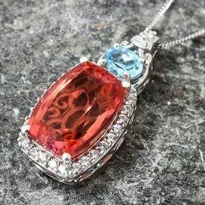 Padparadscha color quartz pendant on granite surface. 