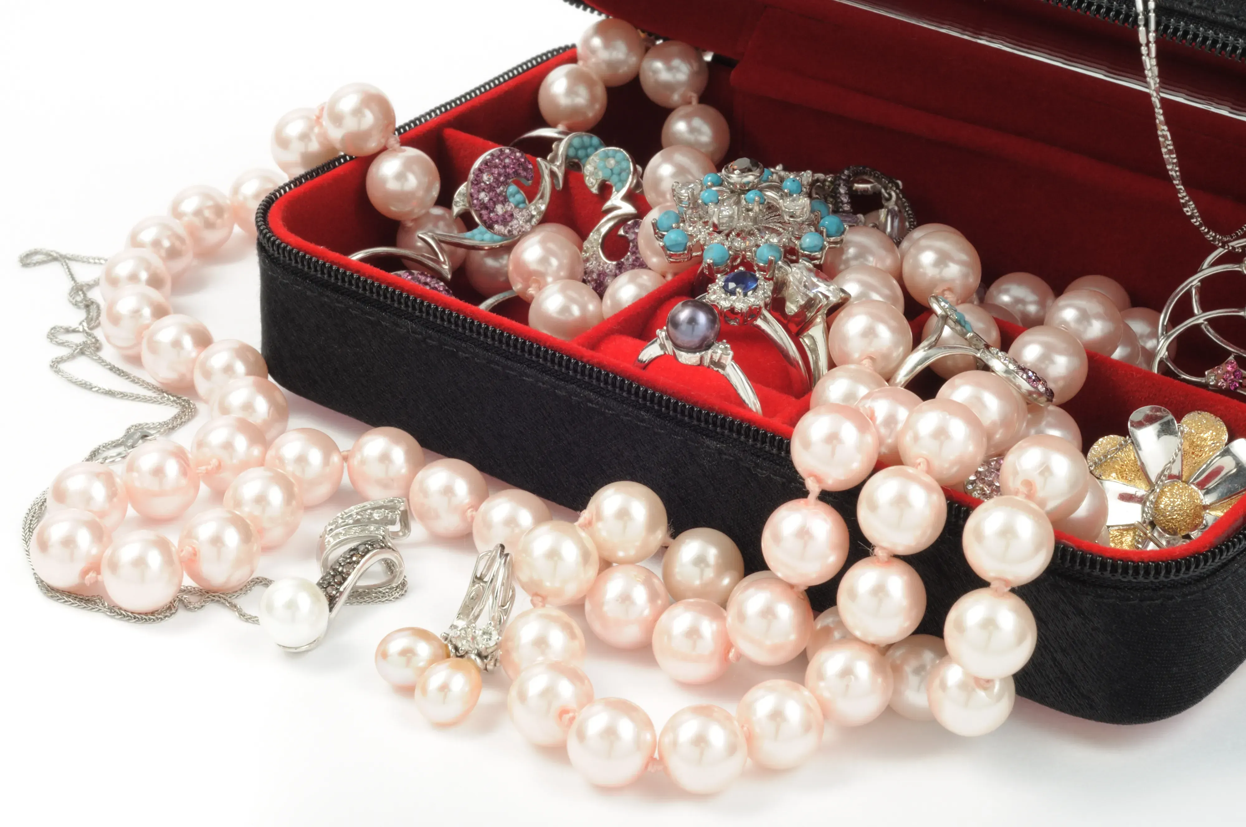 Assortment of pearl jewelry overflowing from jewelry box.