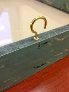 Cup hook inserted into picture frame.