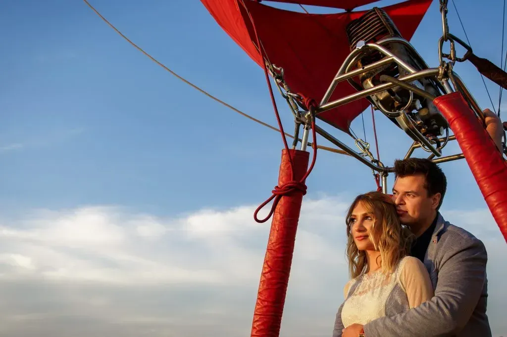 Couple sharing romantic hot air balloon flight.