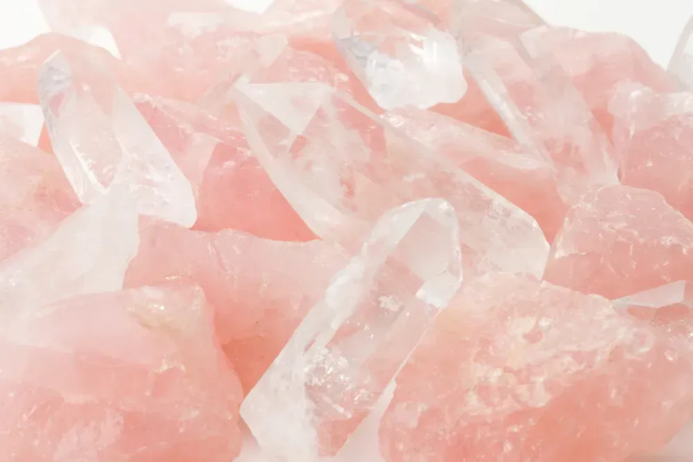 Rose quartz crystal on white background.