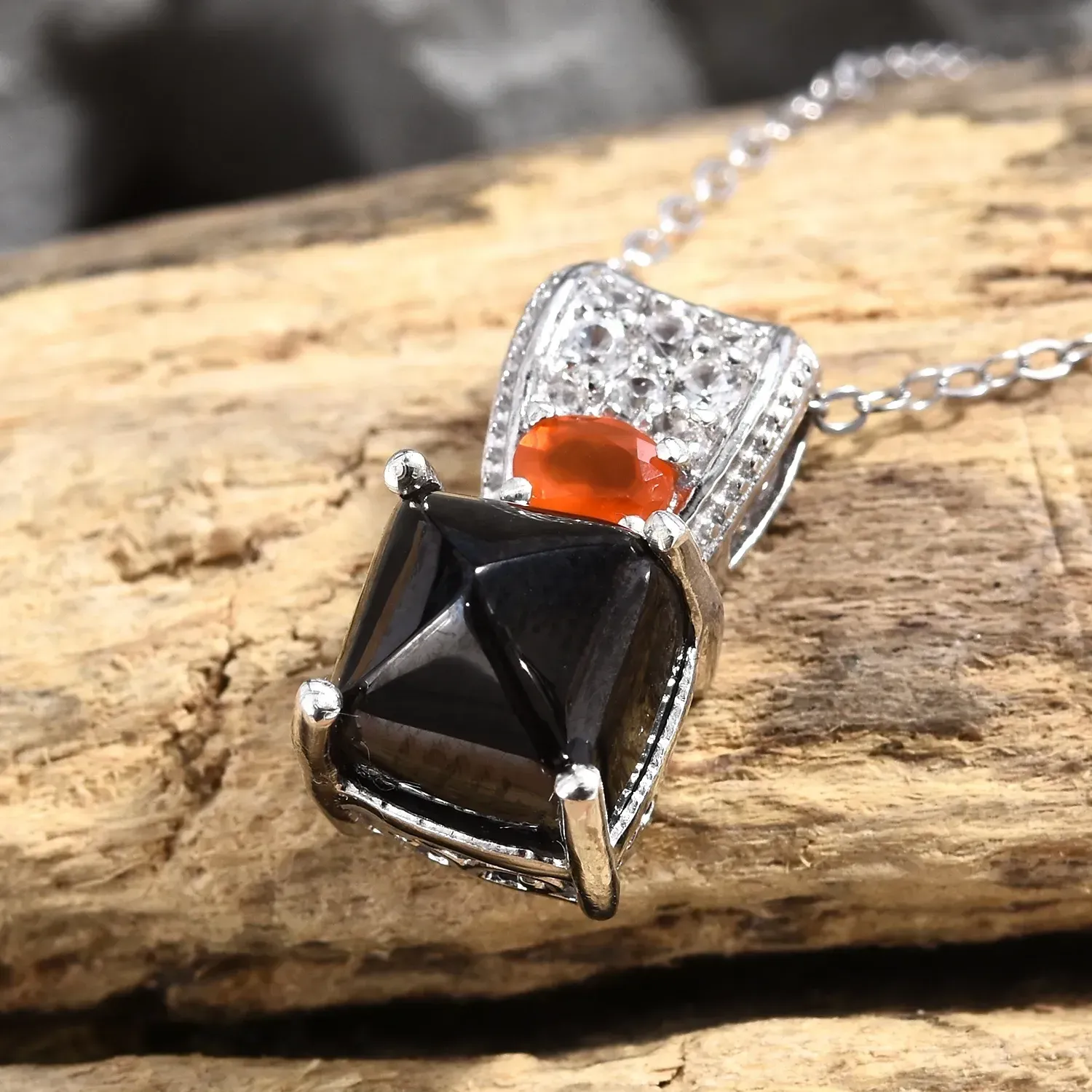Cancer gemstones - Shungite pendant with carnelian accent displayed on drift wood.