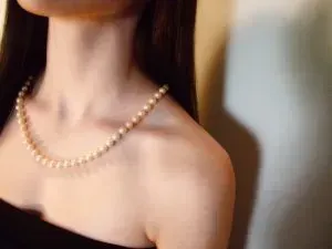 Woman in strapless top with pearl necklace.
