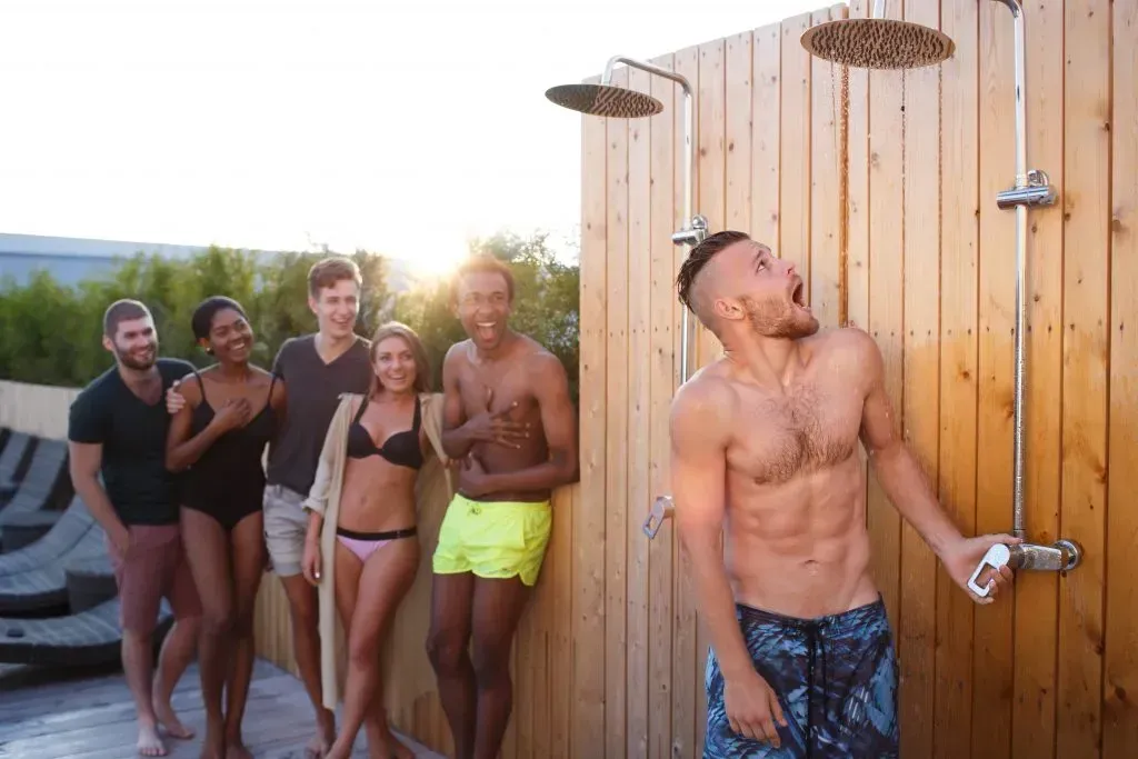 Group of friends hitting the showers after swimming at the pool. 