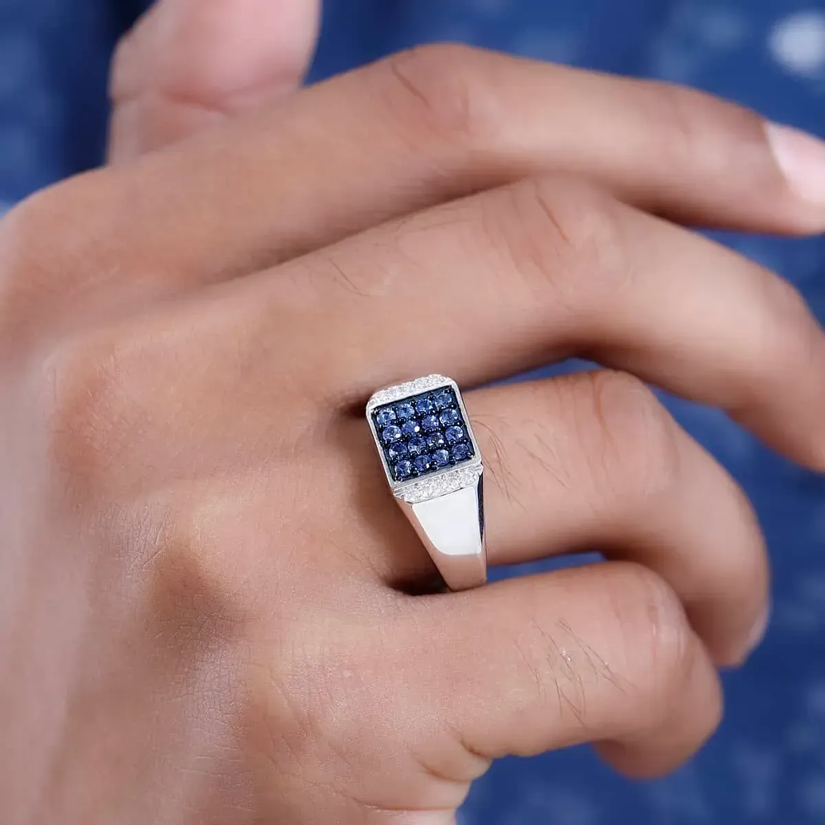 Closeup up of man wearing sapphire ring. 