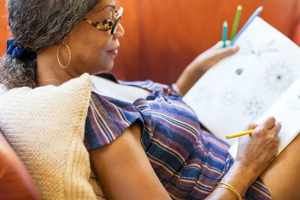 Senior woman coloring in an adult coloring book. 