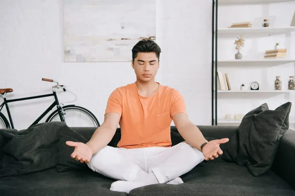 Young man meditation on his couch. 