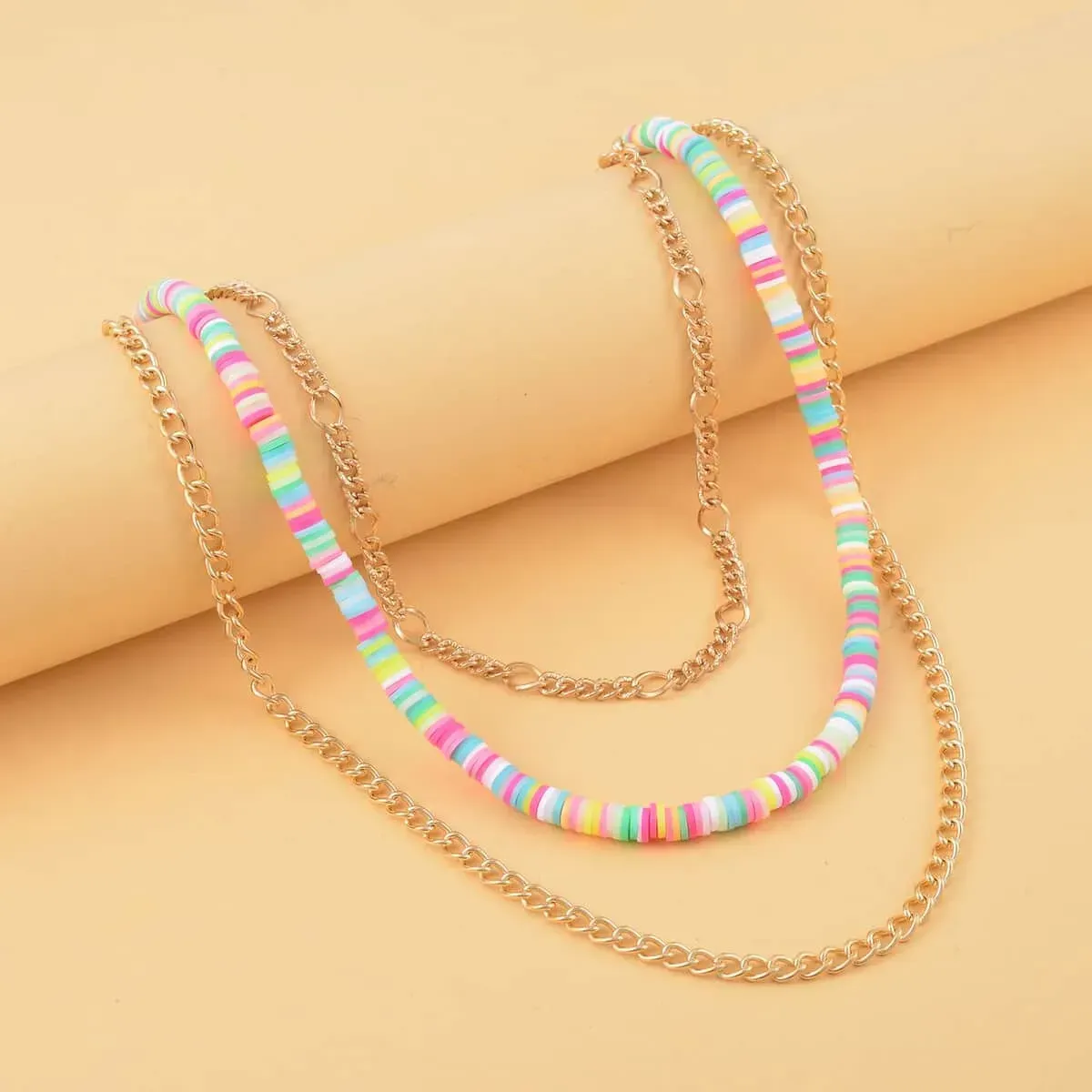 Multi Color Resin Clay 3 Layered Necklace 20-22 Inches in Goldtone on yellow background Multi Color Resin Clay 3 Layered Necklace 20-22 Inches in Goldtone on yellow background