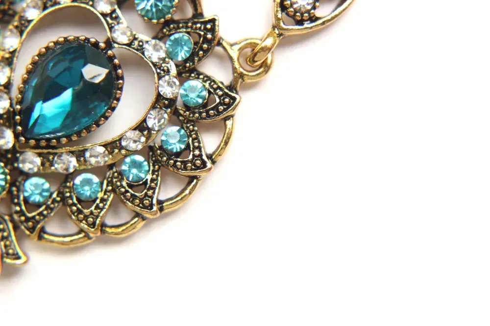 Oriental Turkish women's jewelry with blue gem on a white background.
