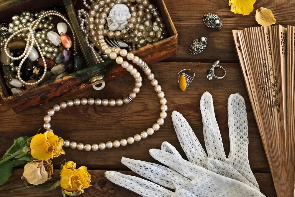 Vintage box with trinkets and jewelry on wooden background.